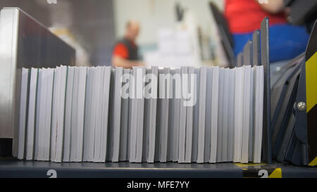 Drücken Sie die Taste Drucken Maschine durch Drücken des Papiers in Typografie Stapel Stockfoto