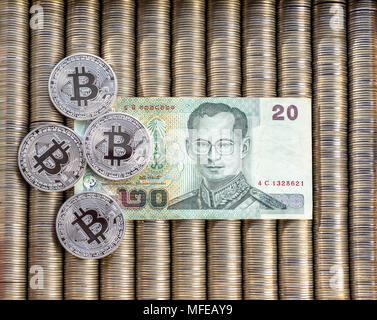 Silber crypto Münzen BTC Bitcoin, Papier Thai Baht. Münzen sind in einen Hintergrund, Blick von oben, crypto Devisenwechsel Stockfoto