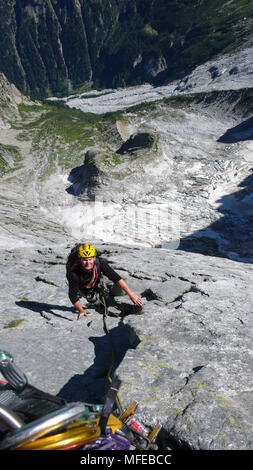 Bergführer auf einer harten Granit Aufstieg zu einer hochalpinen Gipfel in den Schweizer Alpen Stockfoto