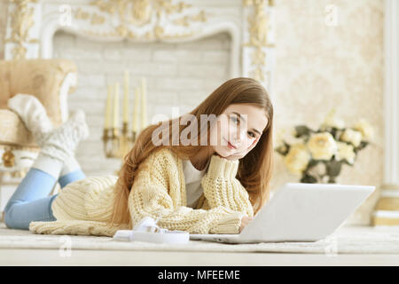 Schöne jugendlich Mädchen liegt auf dem Boden und mit Laptop Stockfoto