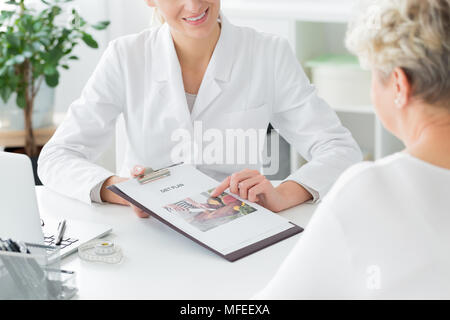 Ein Arzt erklärt ihr Patient über einen Diätplan. Gesundes Leben Konzept Stockfoto