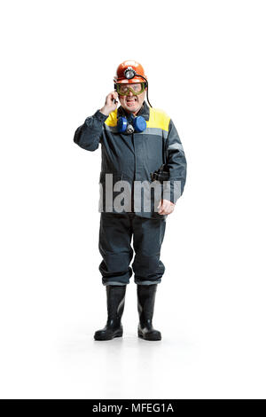 Das Studio shot der verärgerten älterer bärtiger Mann bergmann an der Kamera mit Smartphone auf einem weißen Hintergrund. Stockfoto