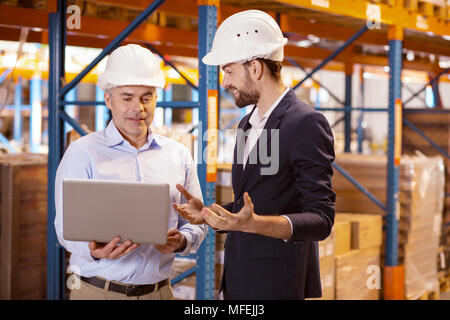 Freudige positive Mann zu seinen Untergebenen Stockfoto