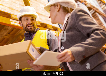 Freudige Delivery Man im Gespräch mit dem Kunden Stockfoto