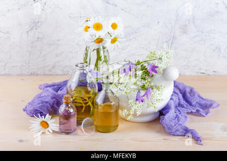 Flaschen mit natürlichen Duft der ätherischen Öle, Mörtel und wilde Blumen, Spa-Konzept. Stockfoto