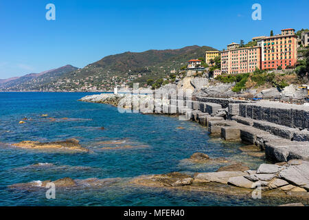 Wave Breaker und bunte Häuser auf Hintergrund in Camogli - kleine Stadt und beliebter Ferienort am Mittelmeer in Italien. Stockfoto