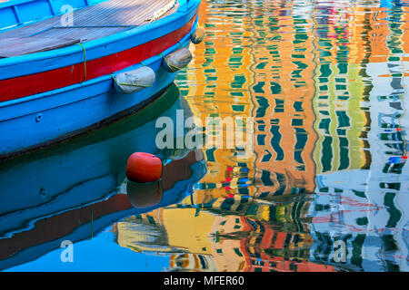 Blau Boot und bunte Spiegelbild auf der Wasseroberfläche in kleinen Stadt Camogli, Italien. Stockfoto