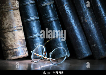 Vintage Brillen auf dunklem Hintergrund, bei der die Zeile der alte Bücher Stockfoto