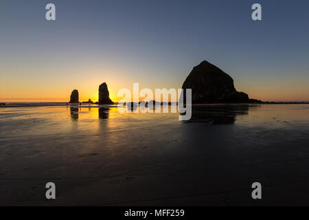 Haystcak Rock und die Nadeln bei Cannon Beach Oregon Küste Ebbe bei Sonnenuntergang Stockfoto