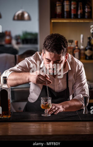 Barkeeper rühren Cocktail auf der Theke Stockfoto