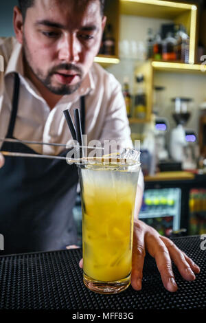 Barkeeper Dekoration ein Glas mit orange Getränk gefüllt mit einer Scheibe Ingwer Stockfoto