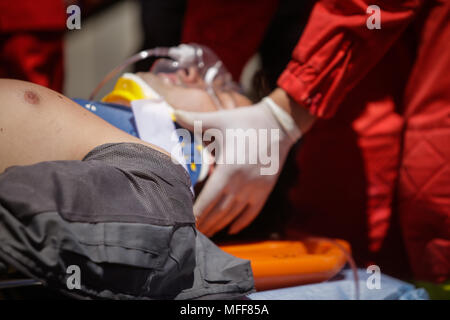 Rescue Feuerwehrleute und Sanitäter nehmen an einem aus verunfallten Fahrzeugen an einen Bohrer Car Crash Site Stockfoto