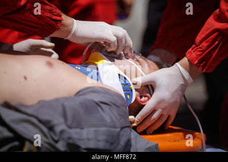 Rescue Feuerwehrleute und Sanitäter nehmen an einem aus verunfallten Fahrzeugen an einen Bohrer Car Crash Site Stockfoto