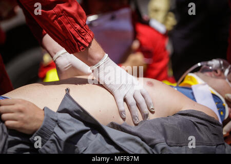 Rescue Feuerwehrleute und Sanitäter nehmen an einem aus verunfallten Fahrzeugen an einen Bohrer Car Crash Site Stockfoto