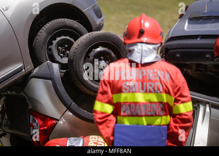 Rescue Feuerwehrleute und Sanitäter nehmen an einem aus verunfallten Fahrzeugen an einen Bohrer Car Crash Site Stockfoto