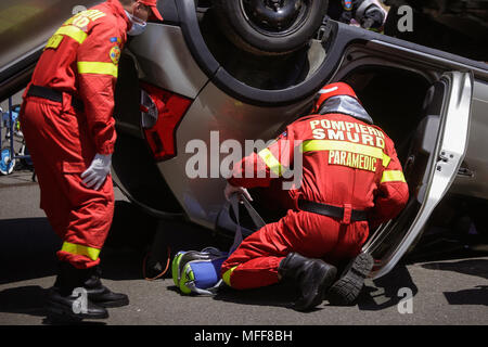 Rescue Feuerwehrleute und Sanitäter nehmen an einem aus verunfallten Fahrzeugen an einen Bohrer Car Crash Site Stockfoto
