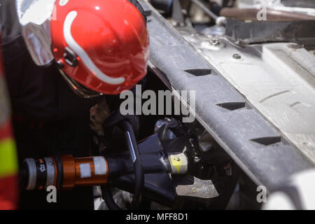 Rescue Feuerwehrleute und Sanitäter nehmen an einem aus verunfallten Fahrzeugen an einen Bohrer Car Crash Site Stockfoto