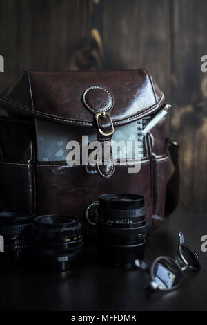 Men's Casual Outfits mit Brown Kamera Tasche und Zubehör auf hölzernen Hintergrund Stockfoto