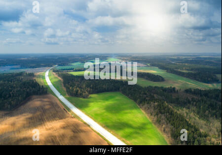 Antenne Frühling Landschaft. Drone Ansicht an der neuen Straße zwischen grünen Feldern. Stockfoto