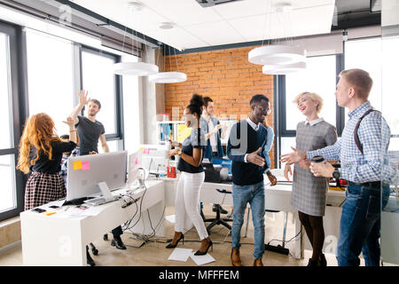 Fröhliche Studenten Team hohe fünf tun und Händeschütteln in Creative Office mit Loft Stil Stockfoto