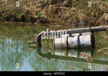 Abwasserrohr in den See auf schwimmende Fässer Stockfoto