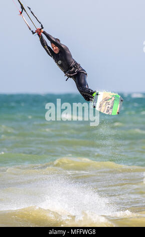 Mann bei einer Bremsung auf See Kitesurfen, fliegen in die Luft. Hochformat. Stockfoto