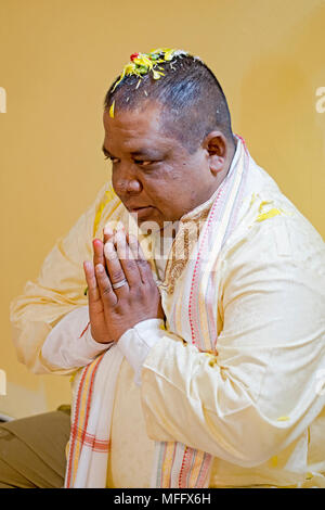 Ein Hindu Anbeter mit Blumen auf dem Kopf als Teil einer Geburtstag Ritual im Shri Lakshmi Narayan Mandir Hindutempel in Richmond Hill, Queens, Stockfoto