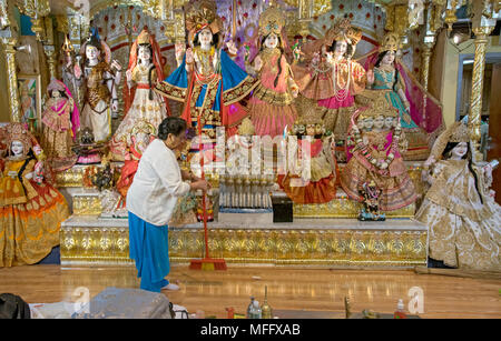 Eine Frau, die Reinigung der nach Dienstleistungen in der Shri Lakshmi Narayan Mandir Tempel in Richmond Hill, Queens, New York, zu verändern. Stockfoto