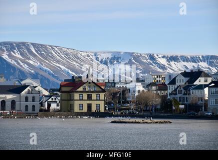 Blick auf Reykjavik Island über zugefrorenen See mit Schnee bedeckte Berge im Hintergrund Stockfoto