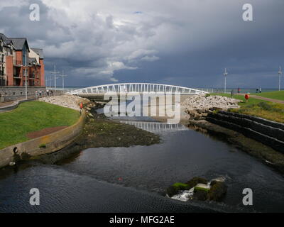 Stürmischen Himmel und eine Fußgängerbrücke in Newcastle, County Down, Nordirland. Stockfoto