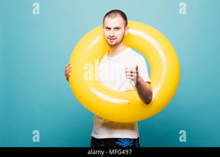 Hübscher Kerl mit aufblasbaren Ring Finger Kamera über grüne Hintergrund isoliert Stockfoto