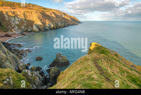 Super Blick auf das Meer von der Spitze der Klippen, Howth Head, in der Nähe von Dublin. Felsbrocken stoppen die brechenden Wellen, Sandstrand, grasbewachsene Hügel und das blaue Meer Stockfoto