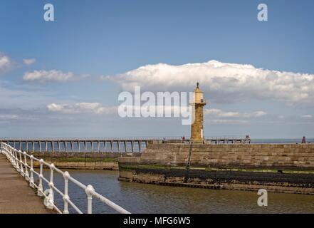 Ein Leuchtturm am Ende der Pier unter einem bewölkten Himmel. Stockfoto