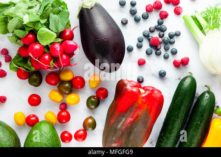 Bunte Obst, Gemüse und Beeren verstreut auf einem Tisch aus weißem Marmor. Hintergrund das Essen gesund essen Stockfoto