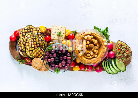Veganen Snack. Flachbild-lay verschiedene vegetarische Gerichte hummus Hummus mit getrockneten Tomaten, Hummus mit getrockneten Tomaten mit Crackern, auberg Stockfoto
