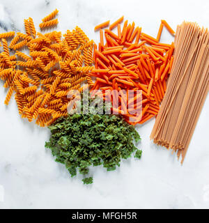 Verschiedene Arten von glutenfreien Paste aus Kichererbsen, rote Linsen, Algen und Gesundes Getreide auf weißem Marmortisch. Schuss von oben. essen Hintergrund Stockfoto