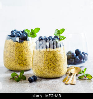 Chia Samen und Mango Püree Milchreis mit Beeren Heidelbeeren und Minze. vegan gesunde Frühstück oder Dessert auf den Tisch Stockfoto