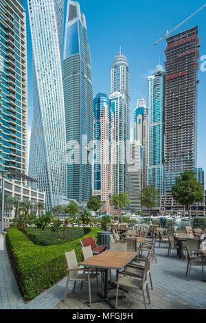 Ein Restaurant im Freien und hohen Gebäuden der Yachthafen von Dubai, Vereinigte Arabische Emirate, Naher Osten. Stockfoto