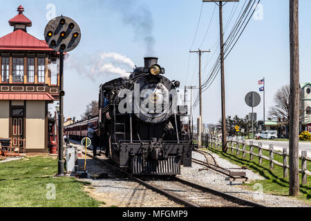 Strasburg, PA, USA - 14. April 2018: Ein smokey Lokomotive von Strasburg Rail Road betrieben zieht in den Bahnhof in Lancaster County, Stockfoto