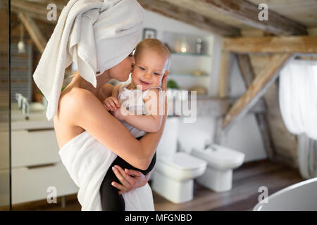 Portrait von glückliche Mutter küssen ihr Baby in der Backe Stockfoto