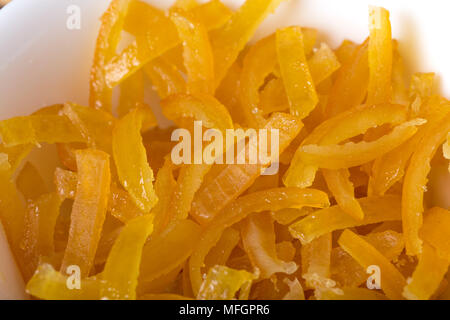 Kandierten Orangenschalen closeup in weiße Schüssel. Makro. Foto kann als Hintergrund verwendet werden. Stockfoto