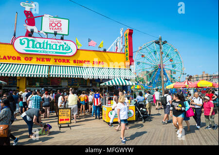 NEW YORK CITY - 20. AUGUST 2017: Besucher gehen die ikonischen Holz- Coney Island boardwalk außerhalb Hot Dog stand die berühmte Nathan an einem heißen Sommertag Stockfoto