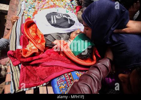 Srinagar, Indien. 25 Apr, 2018. (Anmerkung des Editors: Das Bild zeigt den Tod.) ein Mädchen küsse die Stirn von Ishfaq Ahmad ein lokaler Rebellen im Süden von Kaschmir Handura rund 45 Kilometer von Srinagar im Sommer, die Hauptstadt der indischen Teil Kaschmirs am 25. April 2018 verwaltet. Sechs Menschen, darunter vier Rebellen und zwei Kräfte Personal wurden während der Waffe getötet - Schlacht im Wald im Süden des zentralen Kaschmir, sagte die Polizei. Credit: Faisal Khan/Pacific Press/Alamy leben Nachrichten Stockfoto