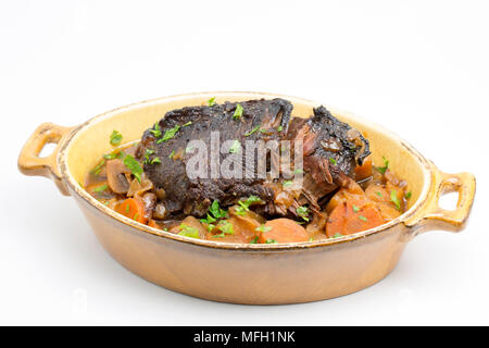 Ein Ochse Wange, die in einem Kupfer Pfanne und dann langsam gekocht in einem Slow Cooker mit Wurzelgemüse und mit gehackter Petersilie garniert angebraten wurde. Stockfoto