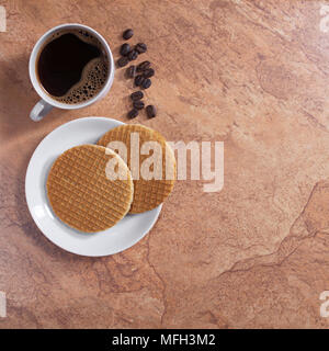 Tasse Kaffee und Waffeln in der Platte auf Stein Hintergrund, Ansicht von oben mit Platz für Text Stockfoto