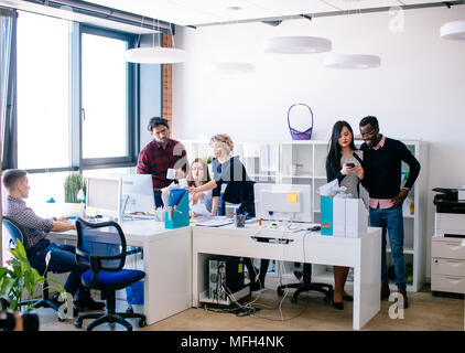 Überfüllten Büro mit jungen aktiven Mitarbeitern. Jeder ist seinen Aufgaben am Arbeitsplatz tun Stockfoto