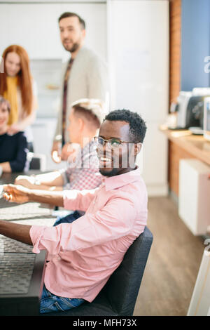 Nahaufnahme Portrait von Happy Mode afrikanischer Mann sitzen auf dem Stuhl am Tisch im Büro Kantine Stockfoto