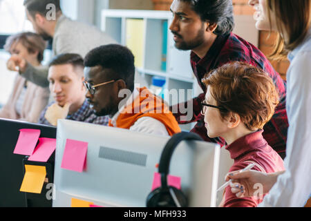 Nahaufnahme 7/8 Bild der vielfältigen Büro sammeln vor Computern in der Loft Innenraum Stockfoto