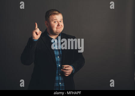 Studio shot der übergewichtigen Jungen Mann mit Anzug nach oben Stockfoto