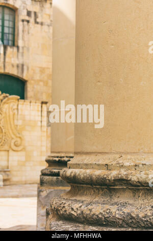 Sandstein Spalten Detail im Zentrum der Stadt. Blur gelbe Fassade Hintergrund. Valletta, Malta Stockfoto